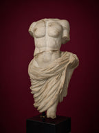 Classical draped male torso sculpture in aged white marble finish mounted on matte black square pedestal